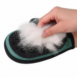 Green silicone pet grooming glove with collected pet fur being removed from rubber bristles