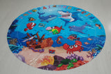 Round plastic mat with underwater animal design on a white surface