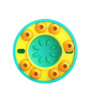 Round yellow and green toy with orange circular elements on a white background