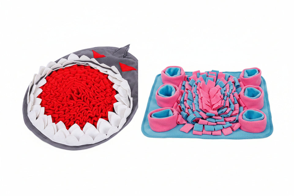 Two textured mats, one shark-shaped and one with pink and blue design, on a white background.