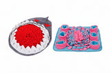 Two textured mats, one shark-shaped and one with pink and blue design, on a white background.