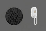 Black silicone mold with flower shapes and a white handheld cleaning brush on a white background